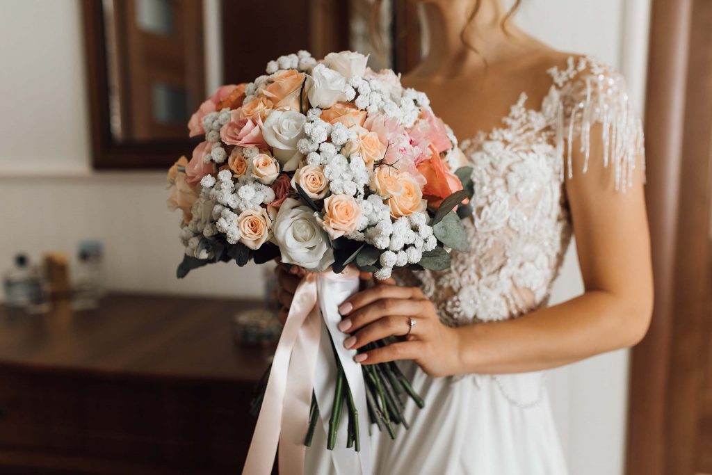 bride-holds-lush-bouquet-with-delicate-flowers-colors